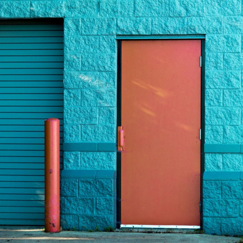 Painting contractors. Commercial Painters. Orange painted door on a blue wall. 