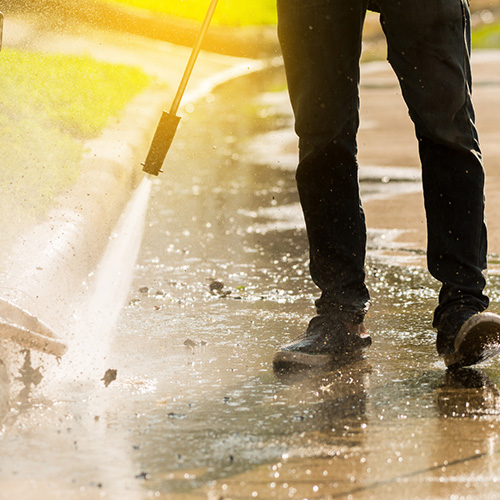 Man power washing outside. 