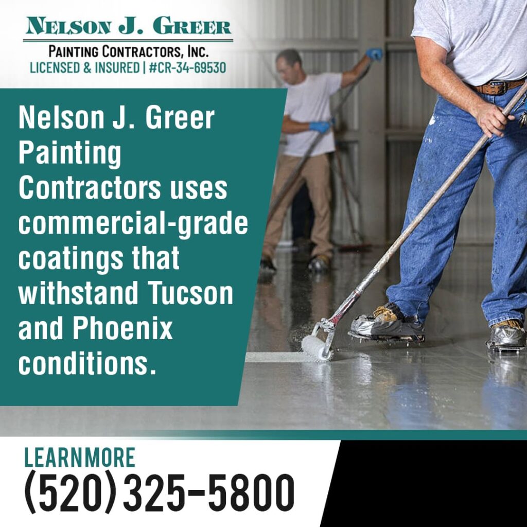 Two painters applying a commercial-grade coating to a concrete floor with rollers.